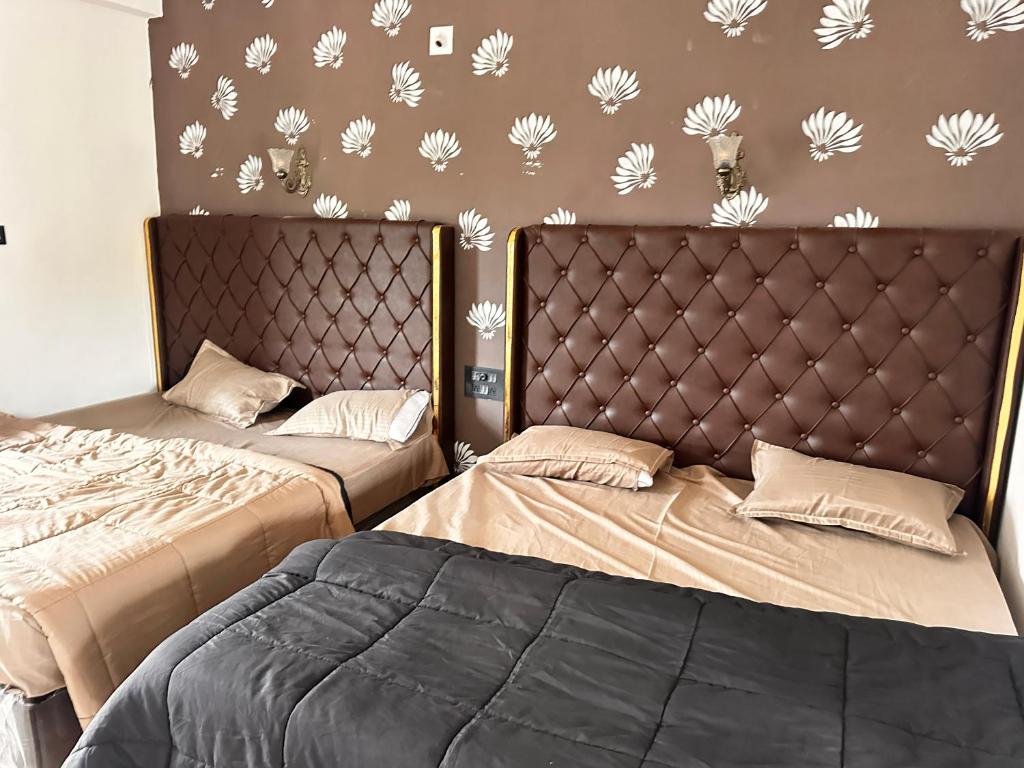two beds sitting next to each other in a bedroom at Rajmahel in Barvāla
