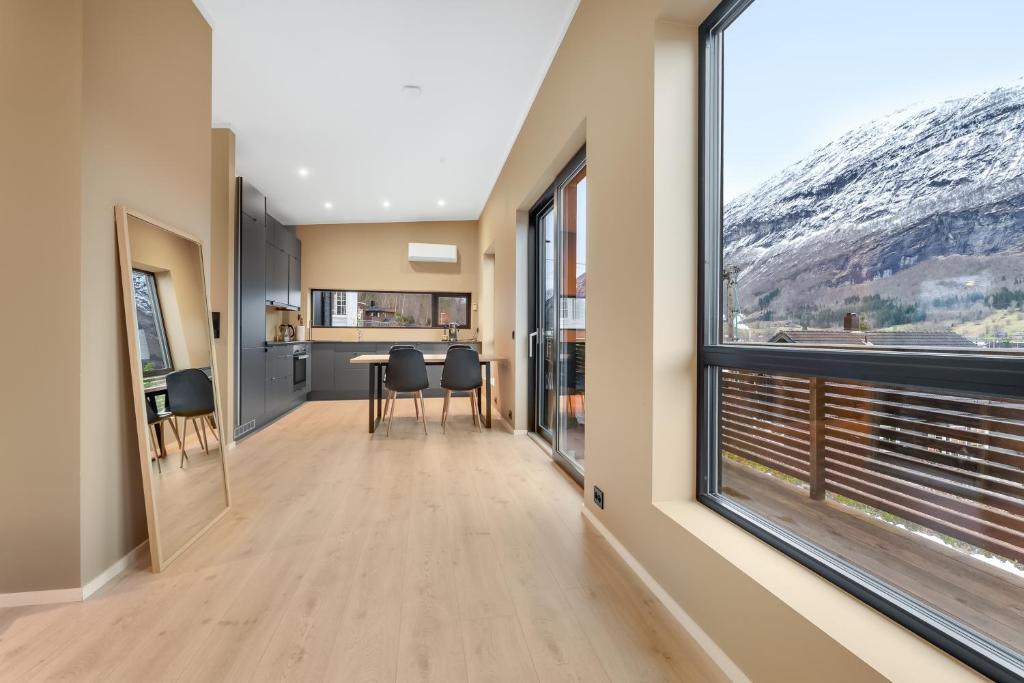 a hallway with a large window and a table with chairs at Aurora Apartments - Stryn View in Stryn