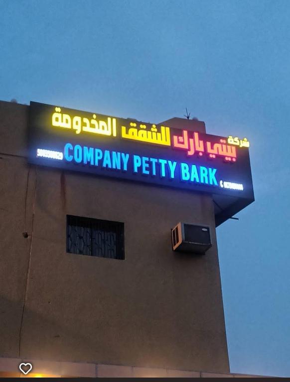 a sign for a company petty bank on the side of a building at company petty bark شركة بيتي بارك للشقق المخدومة درجة اقصادية in Qarār