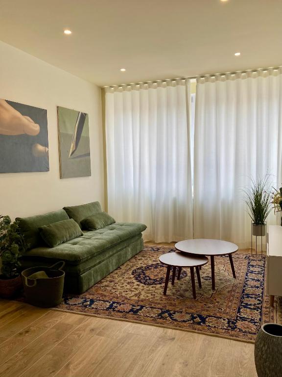 a living room with a green couch and a table at the window in Domodossola