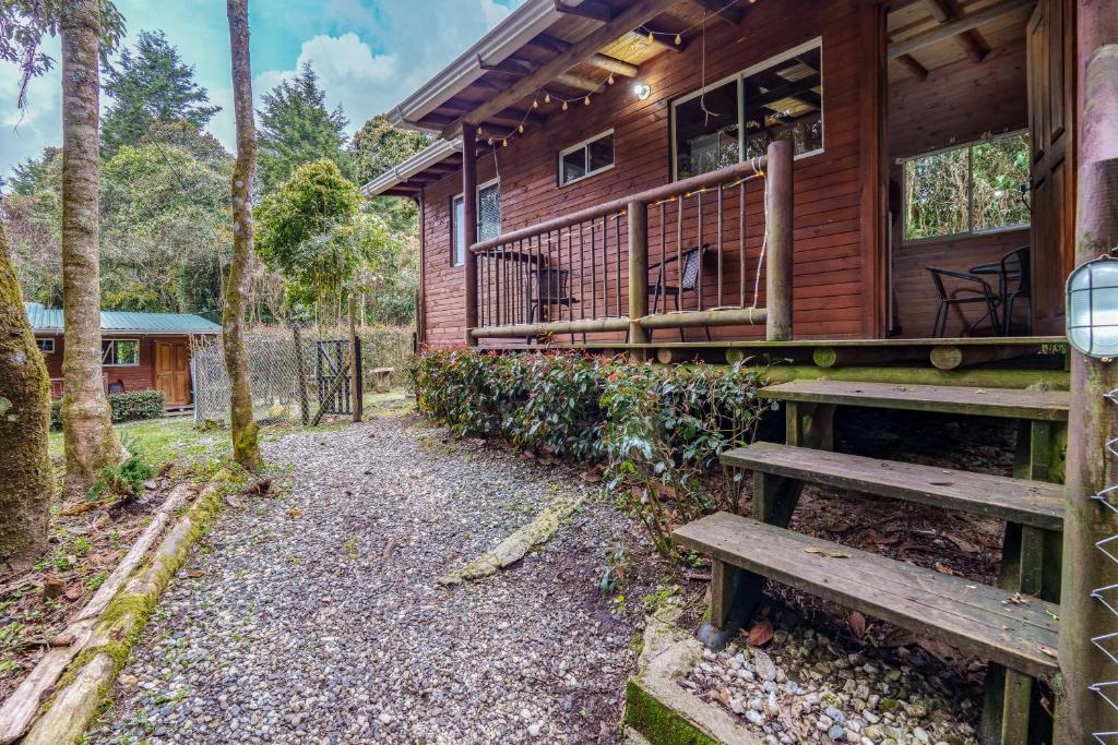 a wooden house with a porch and a bench at Cabañas La Silleta in Santa Elena