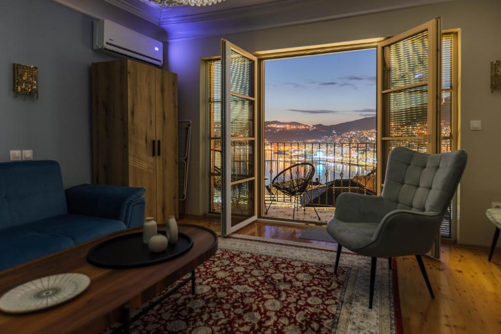 a living room with a couch and a table and a balcony at Mihail Residence - Old Town of Kavala in Kavála