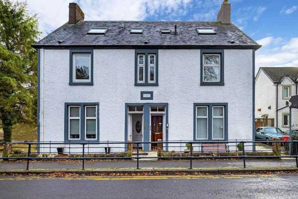 a white house with a gate in front of it at Charming & Cosy Drymen Flat in Drymen