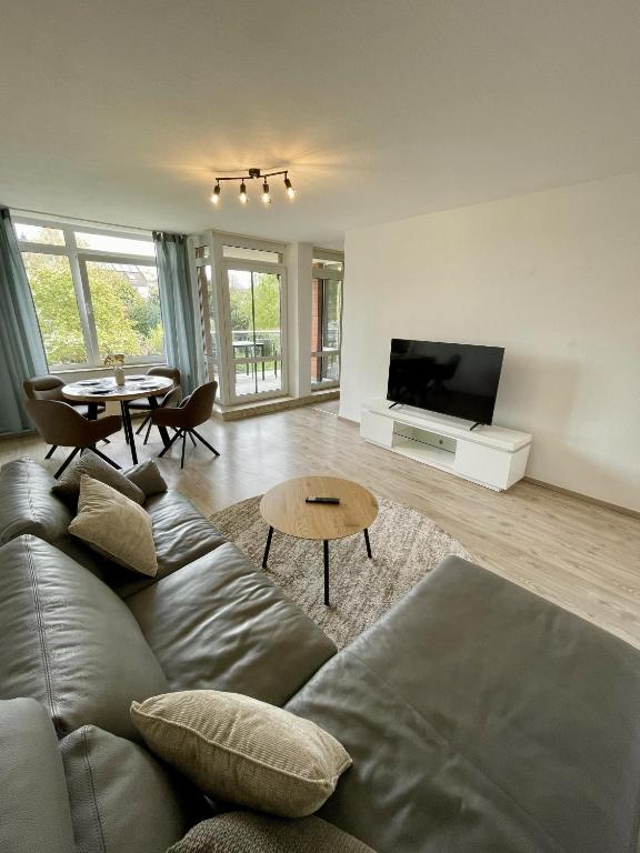 a living room with a couch and a table at Apartment mit Balkon - Nähe CHIO Aachen in Herzogenrath