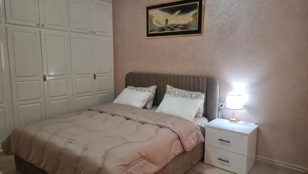 a bedroom with a bed and a night stand with two lamps at appartement luxe in Berkane
