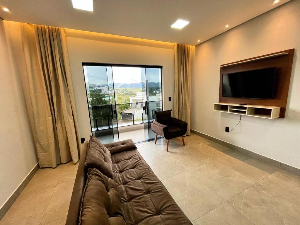 a living room with a couch and a flat screen tv at Casa Centro de Socorro prox a Feira de malhas in Socorro