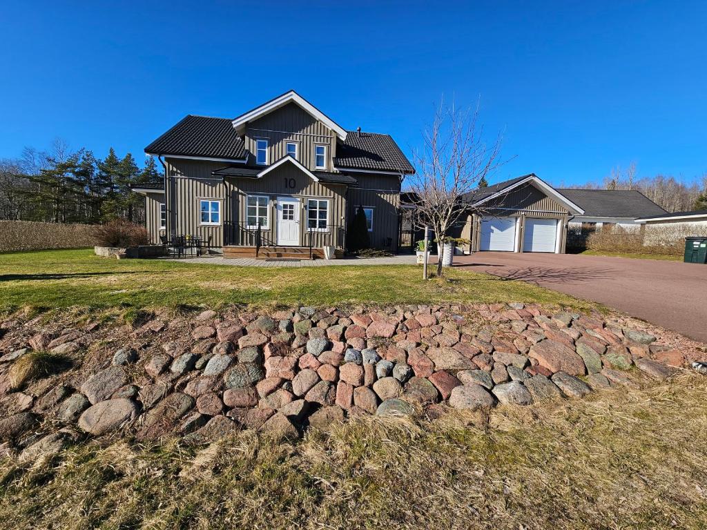 a house with a stone retaining wall in front of it at Fahléns 10 Villa in Jomala