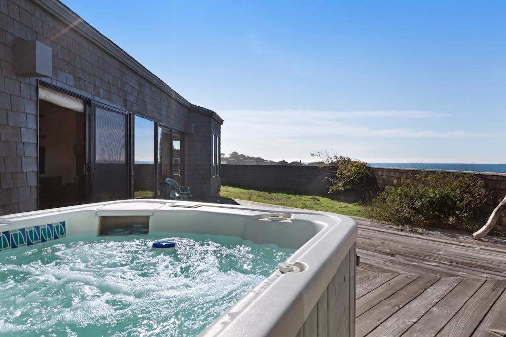 a hot tub on a deck next to a building at Windrow Retreat in Sea Ranch