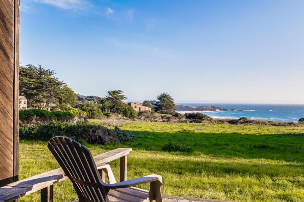 a wooden bench sitting on a porch with a view of the ocean at Vista Grande in Sea Ranch