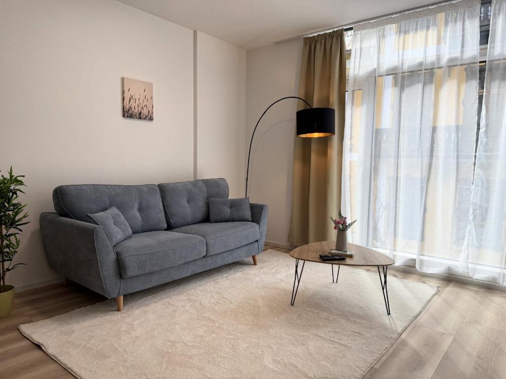a living room with a blue couch and a table at GMA Studio Apartment im Zentrum in Bad Ischl