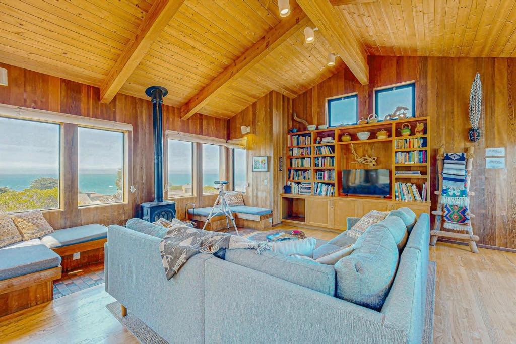 a living room with a blue couch in a room with wooden walls at Gewing House in Sea Ranch