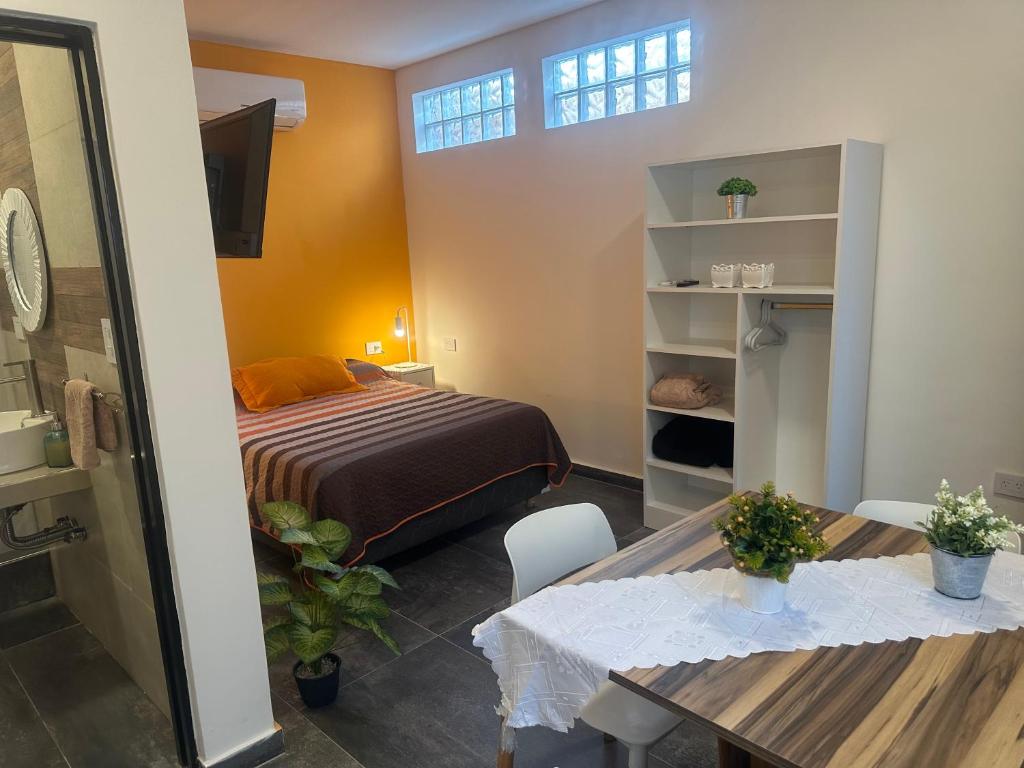 a bedroom with a bed and a table and chairs at Aqui es 6! in Banfield