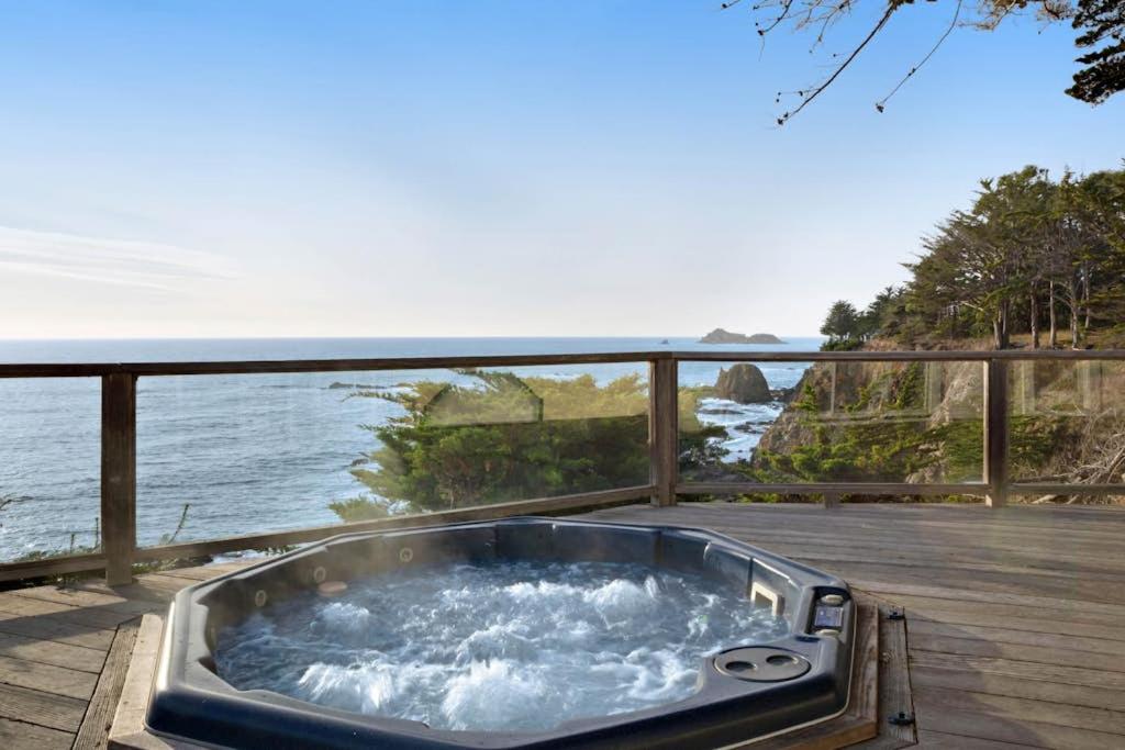 a hot tub on a deck with a view of the ocean at The Cliff House in Gualala