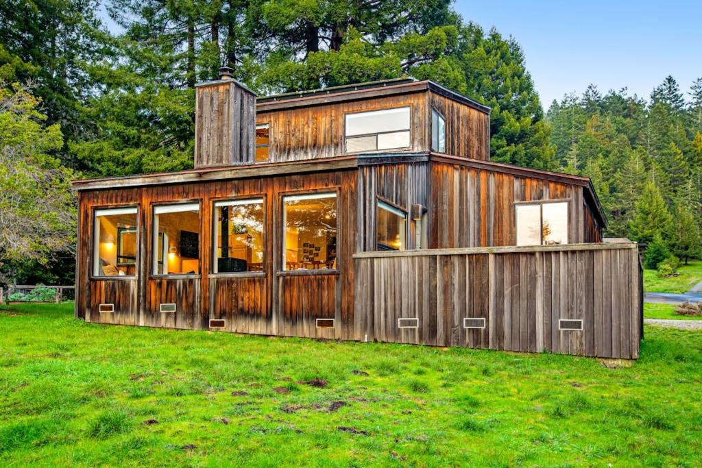 a wooden house in a field of grass at The Bobcat House in Sea Ranch