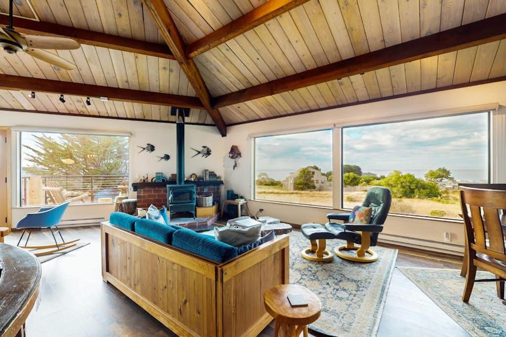 a living room with a blue couch and windows at Seas the Day in Sea Ranch