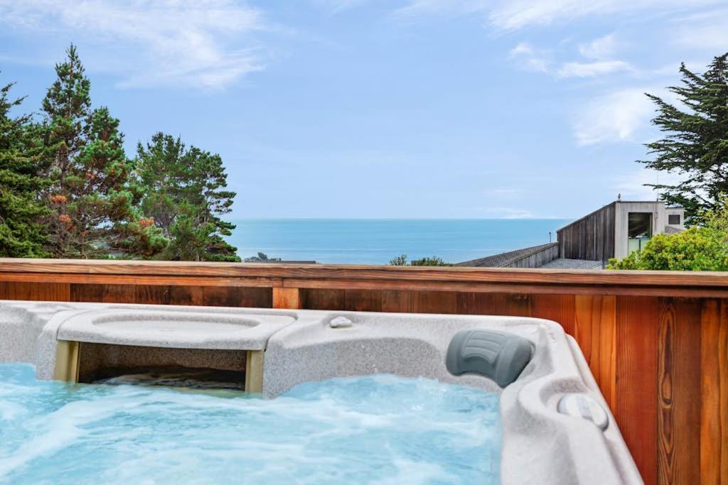 a hot tub on a fence with the ocean in the background at Rainbow's End in Valley Crossing