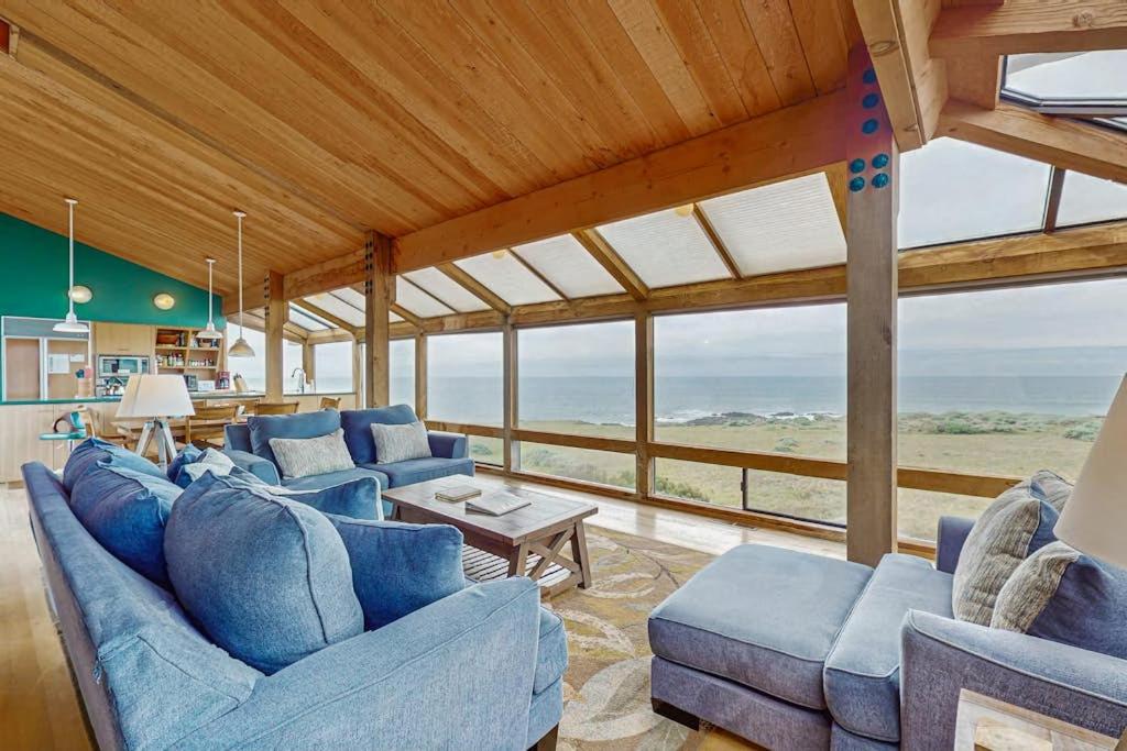 a living room with blue couches and a table at Compass Rose in Sea Ranch