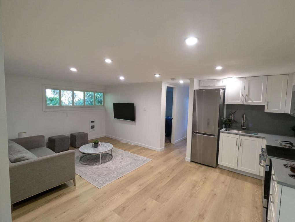 a kitchen and a living room with a couch and a table at Entire Garden Suite in North Vancouver in North Vancouver