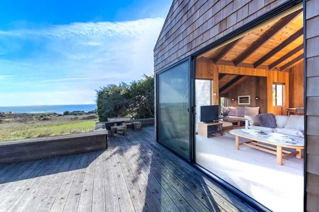 a house with a deck with a view of the ocean at The Glass House in Sea Ranch