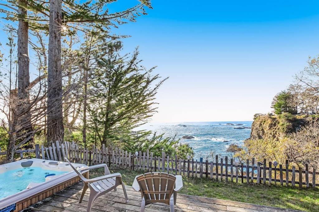 a backyard with a hot tub and chairs and the ocean at Cove House in Gualala