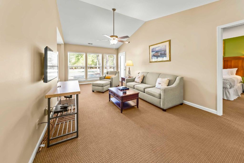 a living room with a couch and a table at Luxury Condo with Golf Course Views Pools & Resort Access in New Bern