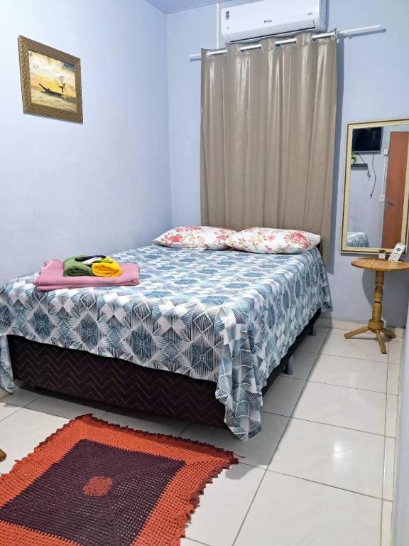 a bedroom with a bed with a blue blanket and pillows at aguapé apartamento 2 in Barreirinhas