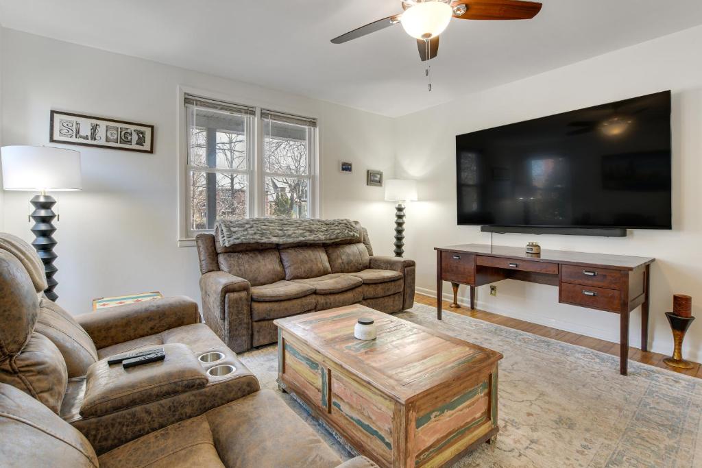 a living room with two couches and a flat screen tv at Spacious Chicago Group Home! Walk to Train & Eats in Chicago