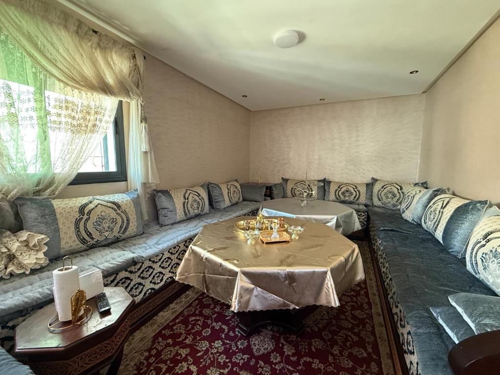 a living room with a couch and a table at Dar AMIRA in Ben Yakhlef
