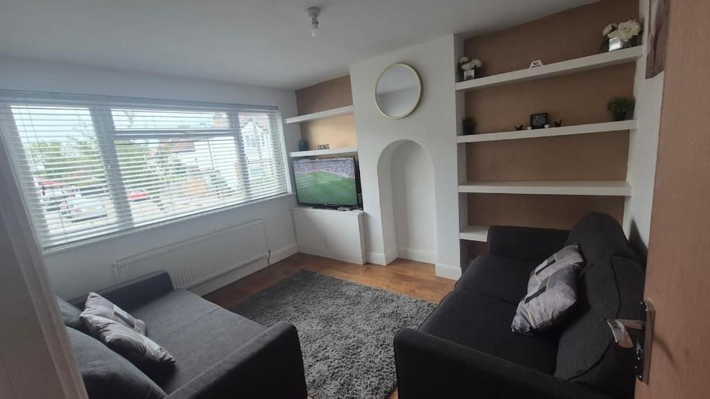 a living room with a couch and a tv at Brooklyn House in Elmers End