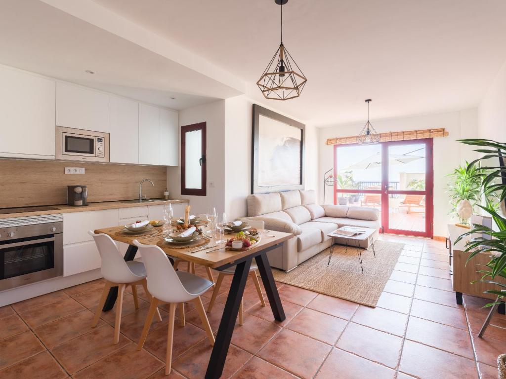 a kitchen and living room with a table and chairs at Giraud II - Beachfront - Pool - 46 m2 Terrace in Santa Maria de Guia de Gran Canaria