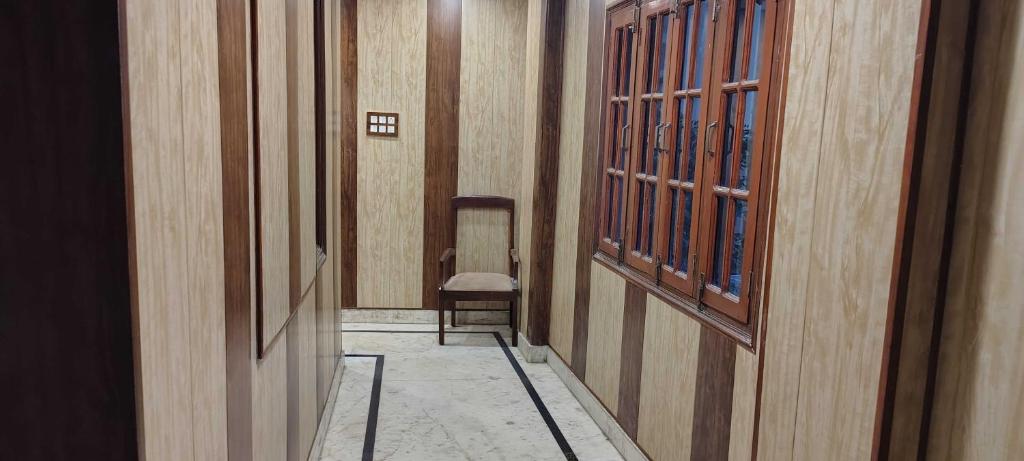 a hallway with a chair in a building at Hotel O HOTE V-SQUARE in Lucknow