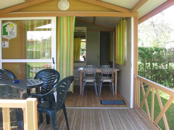un porche con sillas y una mesa en una terraza en Camping Sella, en Arriondas