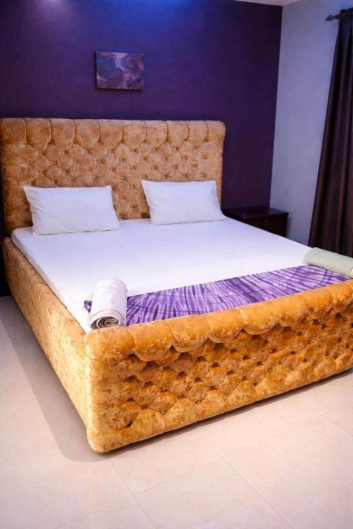 a bedroom with a large bed with a wooden headboard at Cutting Edge Guest House in Daranka