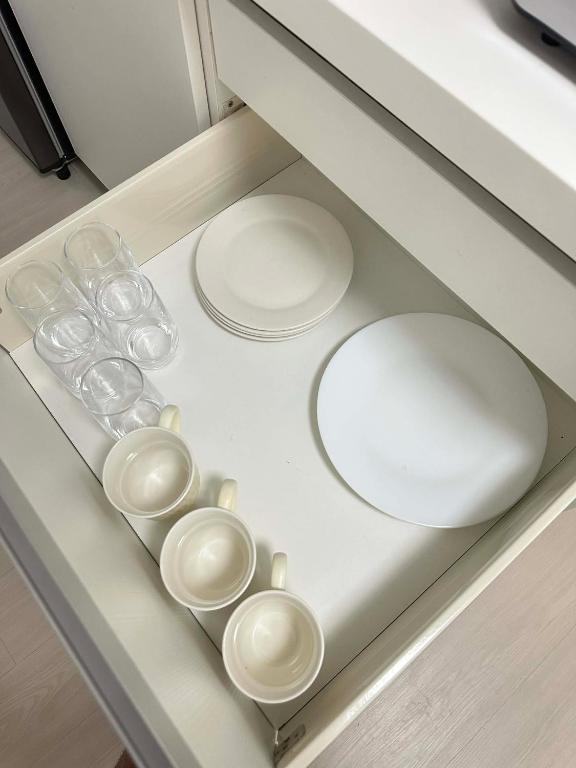 a drawer with plates and bowls and glasses on it at The Waltham Place in Lagundi