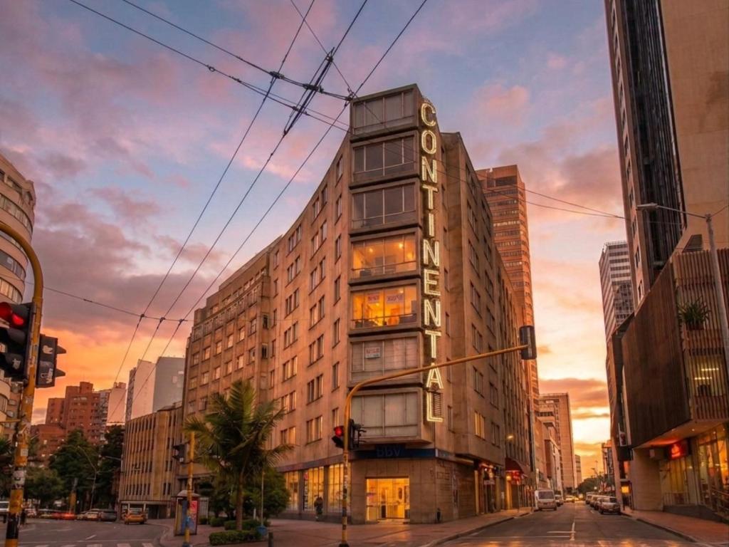 a tall building on a city street at sunset at Continental Aparthotel Bogotá - Aparta Suite in Bogotá