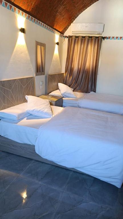 a group of three beds in a room at Kenzy House Abu Simbel in Abu Simbel