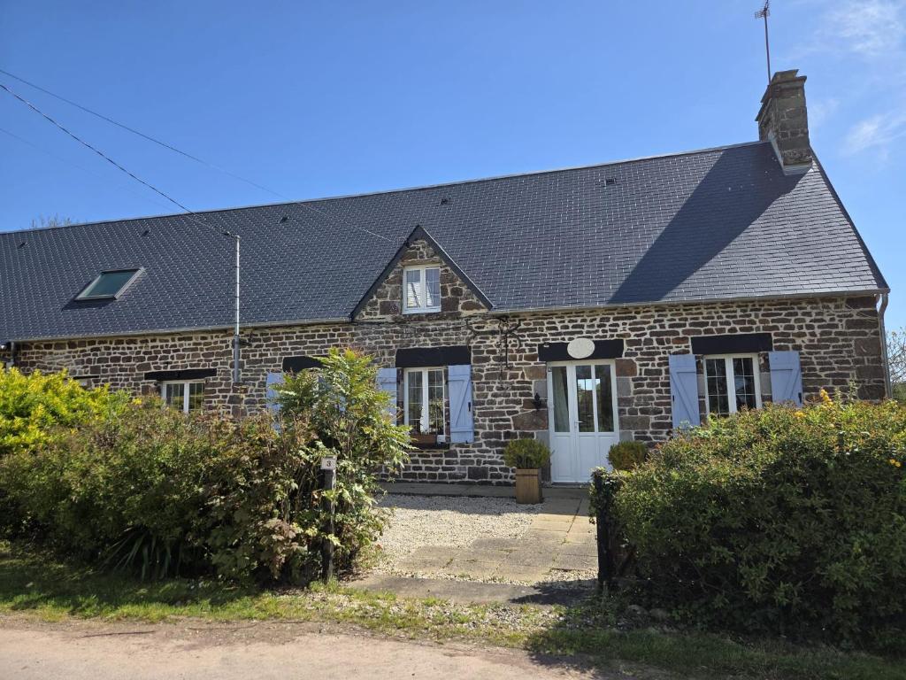 a brick house with a black roof at Gîte la belle etoile proche de Granville in Ver