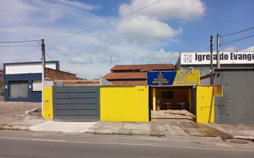 a yellow building on the side of a street at Pousada Imperatriz in Aparecida