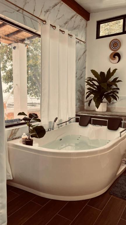 a large white tub in a bathroom with a window at Casa Amanecer in Tonosí