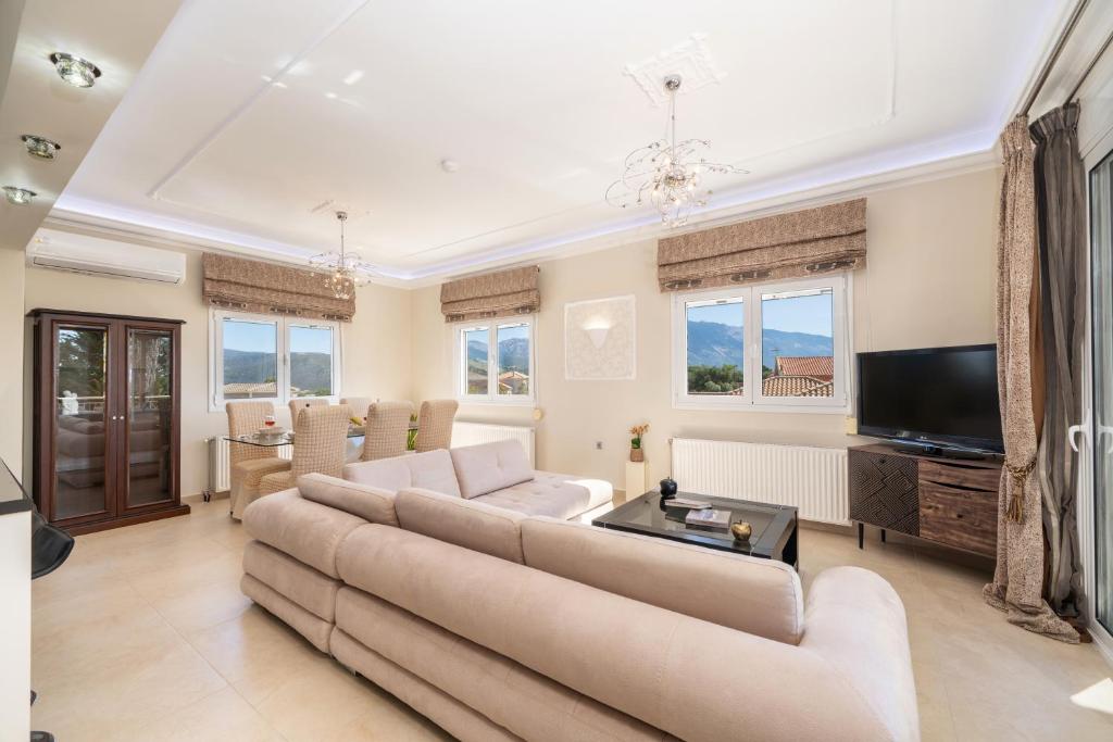 a living room with a couch and a tv at Gerasimos Dream House - 7 Minutes from the Airport in Lakíthra