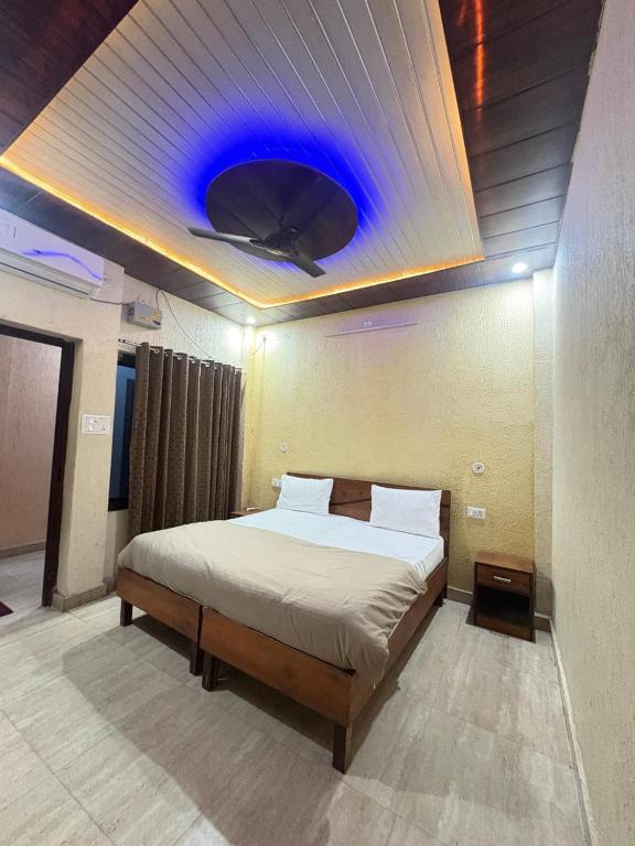 a bedroom with a bed with a blue ceiling at HOTEL O DEV RAJ Homestay in Rishīkesh