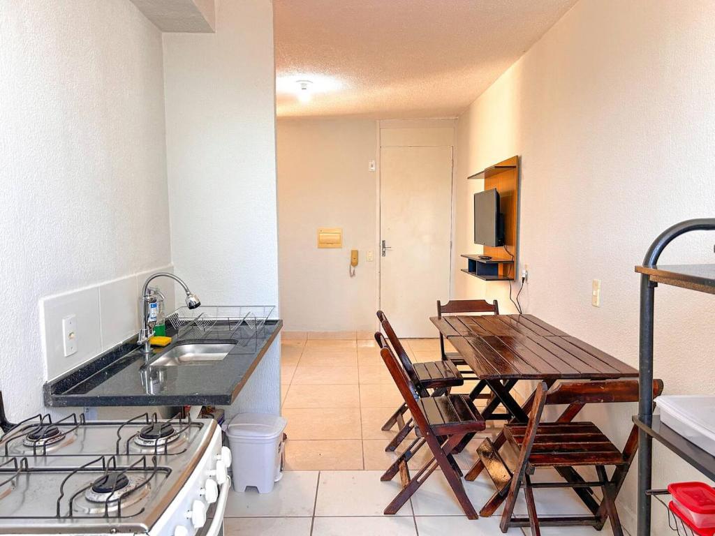 a kitchen with a sink and a table with chairs at Aconchego e praticidade ao lado da BR-040 in Luziânia