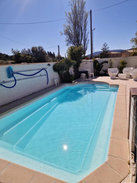 ein großes Schwimmbecken mit Stühlen drumherum in der Unterkunft Cassis la gare in Cassis