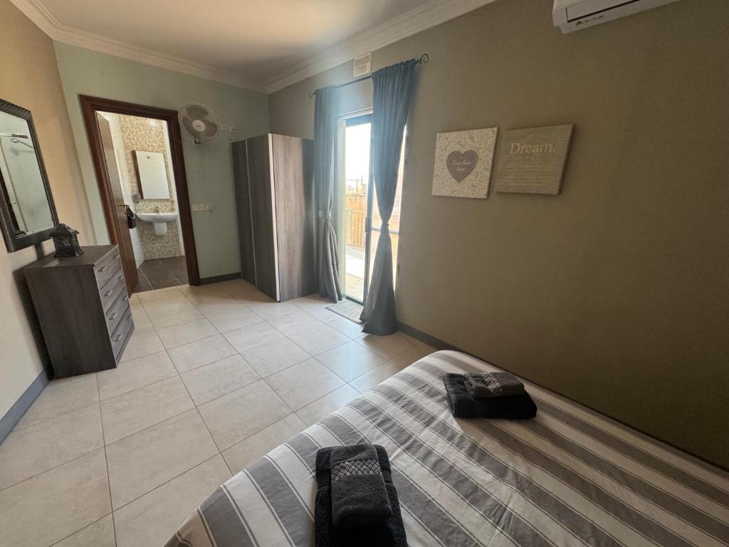 a bedroom with a bed and a bathroom at Tommy's Retreat Xewkija in Xewkija