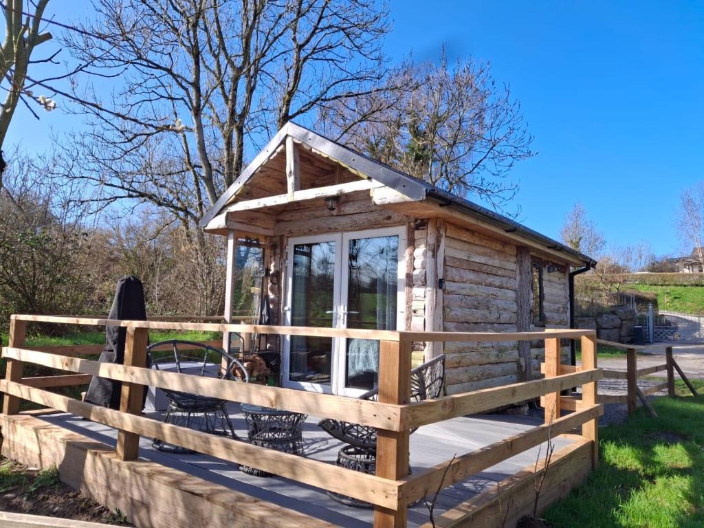 a wooden cabin with a fence around it at Riverside cabin in Limerick