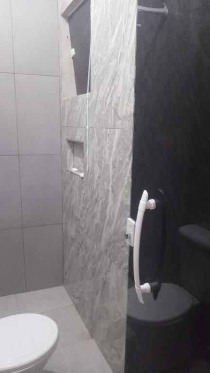 a bathroom with a shower with a toilet and a sink at Onda's suíte in Paraty