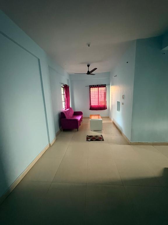 a living room with a purple couch and a window at Apna Ghar in Bhopal