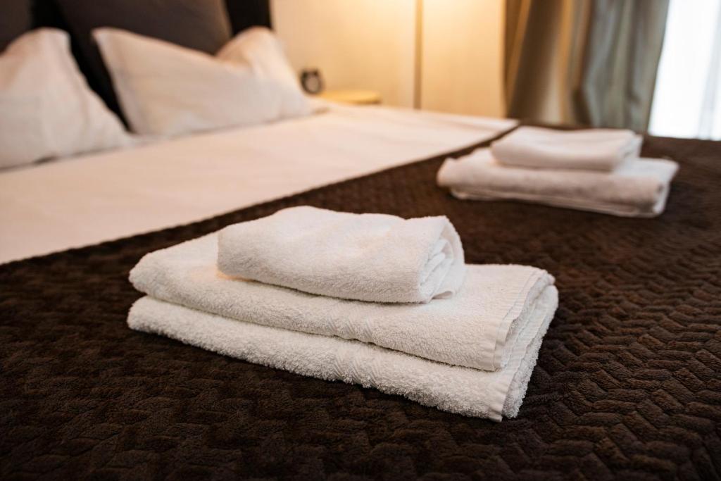 a pile of towels sitting on top of a bed at Seyra Home Studio - Modern Flat Pool Free Parking Self Check-in in Ştefăneştii de Sus