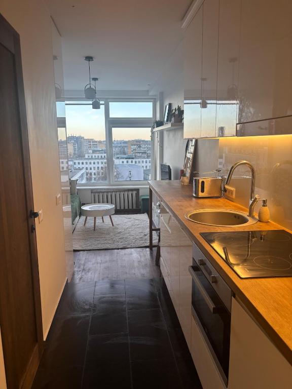 a kitchen with a sink and a view of a room at Cosy Newtown apartment in Vilnius