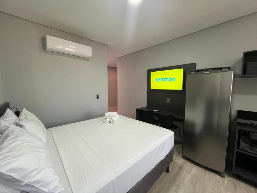 a bedroom with a white bed and a television at Town Co - Apartment 1004 in Porto Alegre